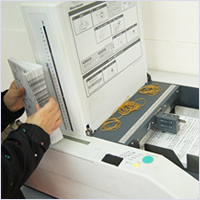 印刷物チラシの折加工サービス。当社の折加工機械と作業風景画像
